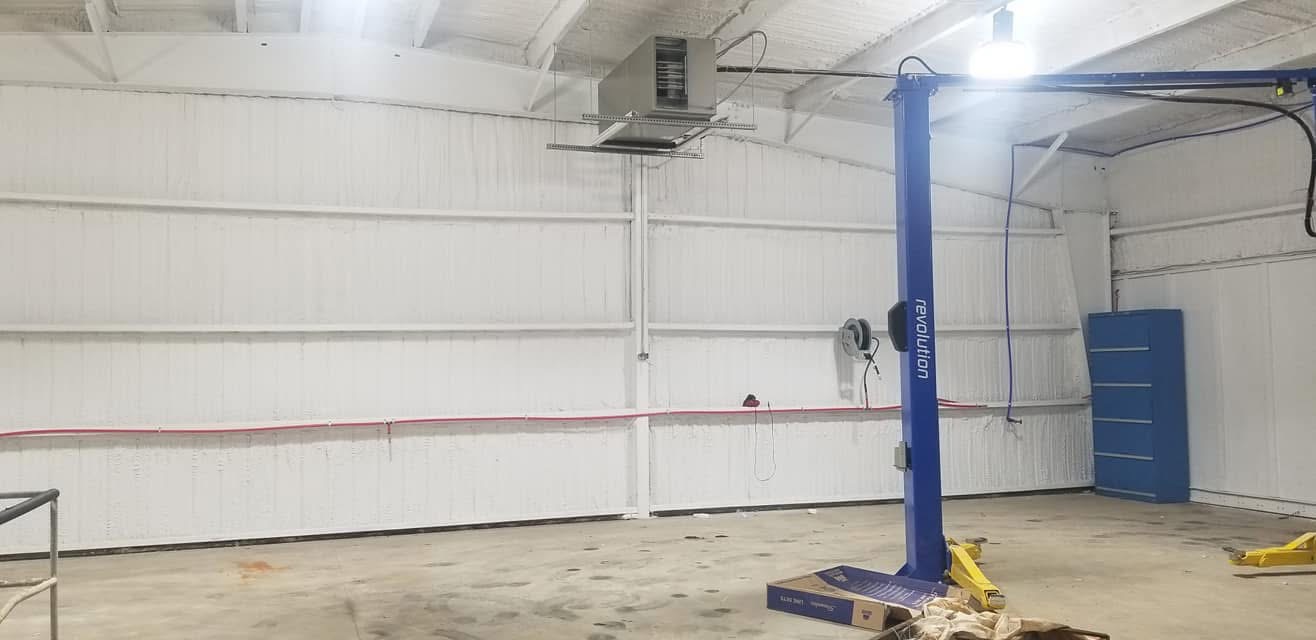 Finished commercial shop with spray foam walls and car lift installed